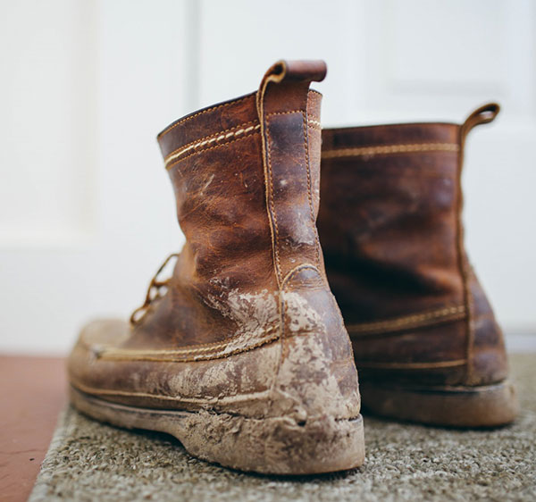 Dirty boots on floor mat